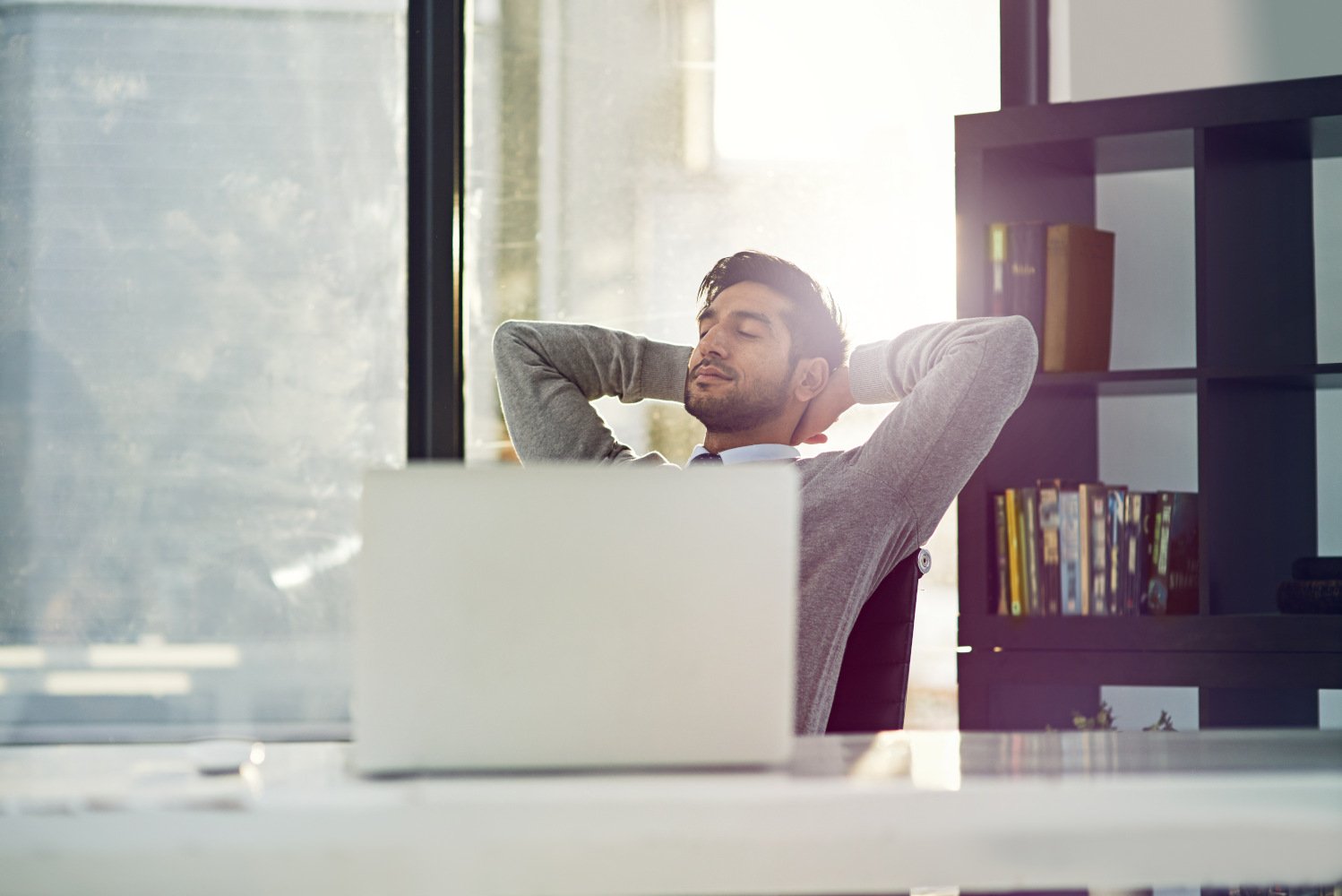 Illustration of a person sitting at a desk with a laptop, taking a break to prioritize mental health, symbolizing the importance of requesting a mental health day.